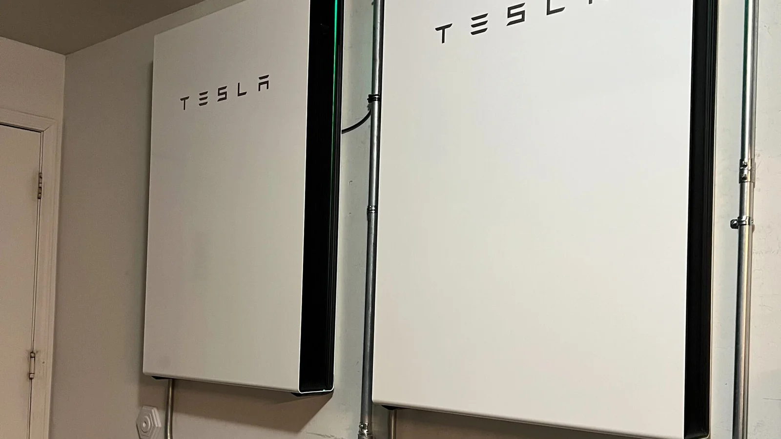 Tesla Powerwall 3 mounted on an exterior wall of a Melbourne home with solar panels visible on the roof
