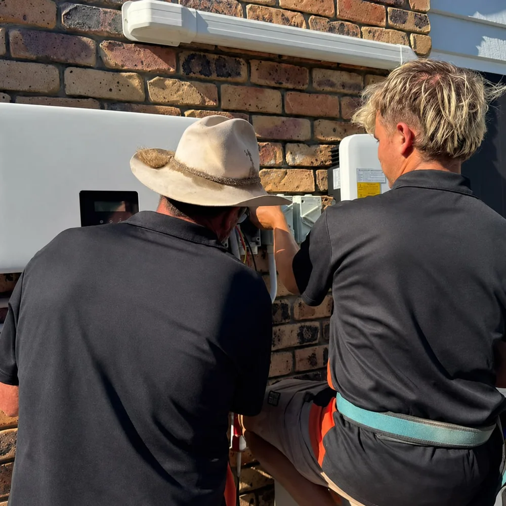 Two members of the Solar Batteries Melbourne team finishing a home solar battery installation at a Melbourne house