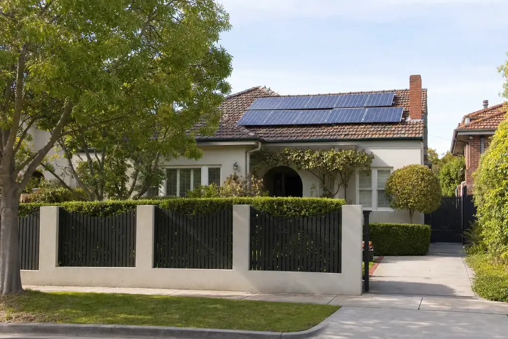 Wall-mounted solar battery inside the garage of a Camberwell interwar brick home, with well-spaced solar panels on the tiled north-facing roof