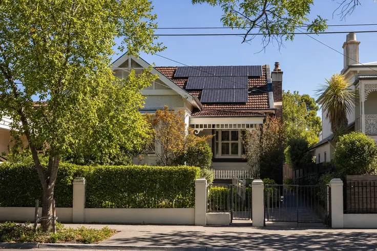 Solar battery unit in the double garage of a Hawthorn Edwardian brick home, with a large north-facing solar array spanning the entire roof visible from the driveway
