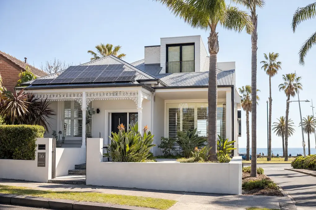 Solar battery system installed on the exterior wall of a St Kilda bayside home with rooftop solar visible